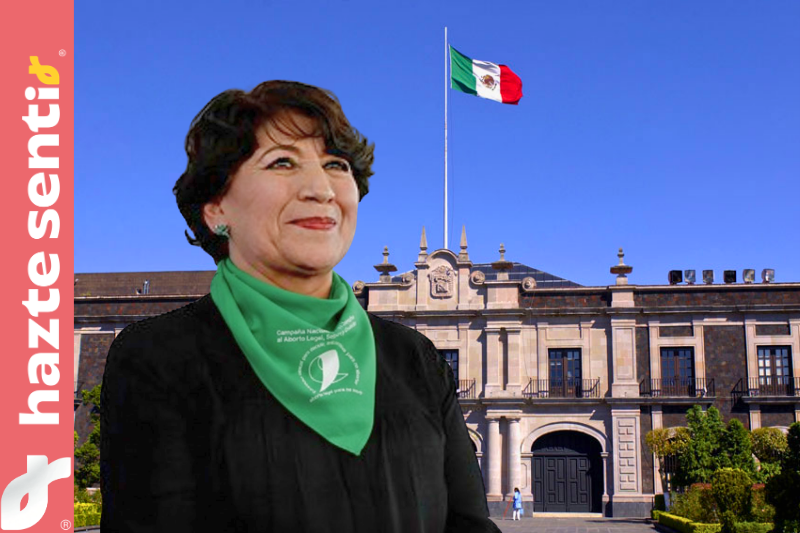 Gobernadora Delfina Gómez con pañuelo verde pro-aborto frente a un fondo representativo del Estado de México, simbolizando la imposición de la agenda abortista.