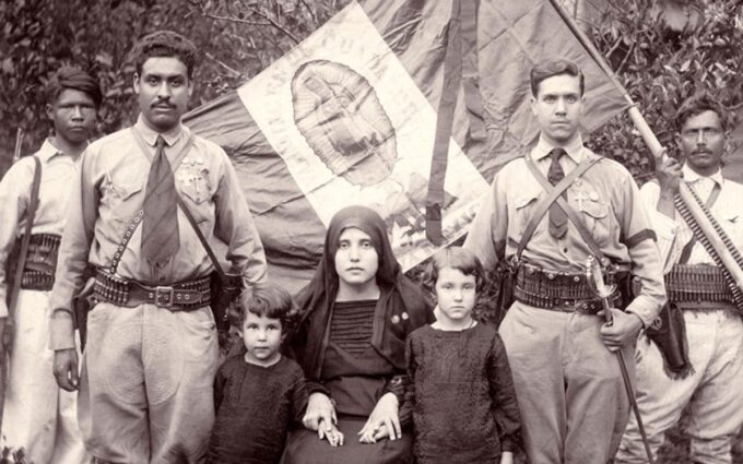 Rosario de madera y Biblia apoyados sobre la bandera histórica mexicana de la Guerra Cristera.